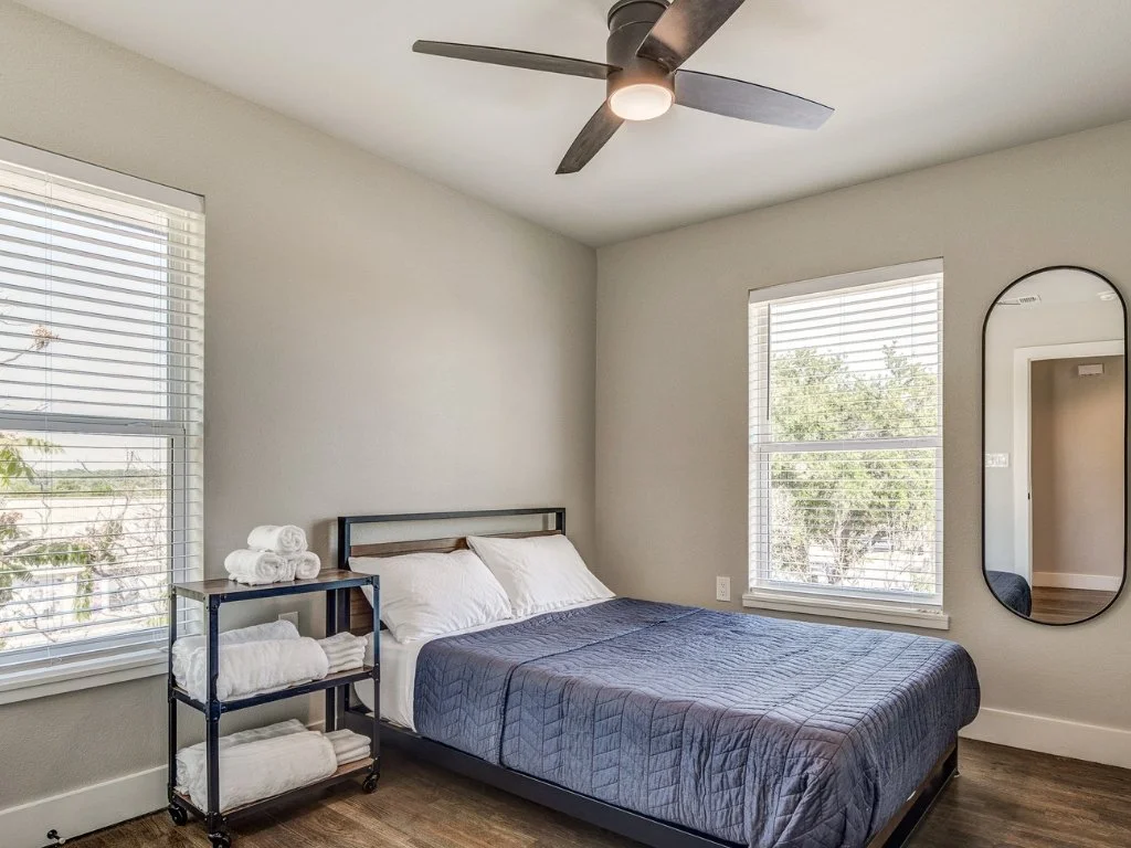 Bright White Rock Views bedroom with two windows and soft natural light.