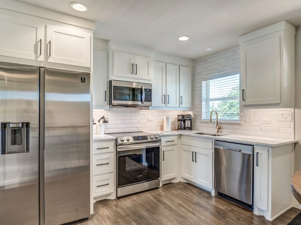 White Rock Views kitchen with white cabinetry and subway tile.